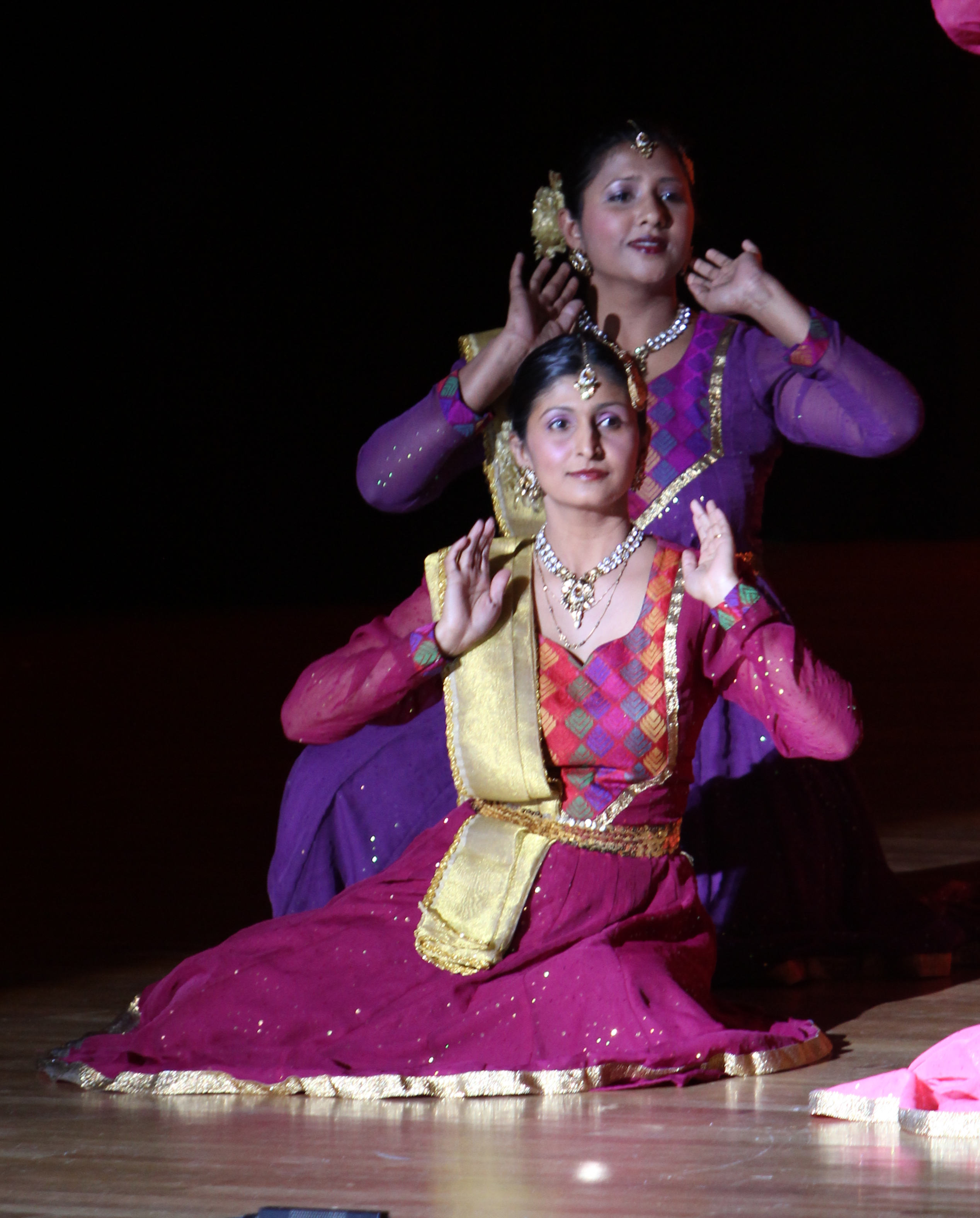 Sapna Adhikari and Aarti Gupta performing Kathak on stage in purple and magenta lehengas