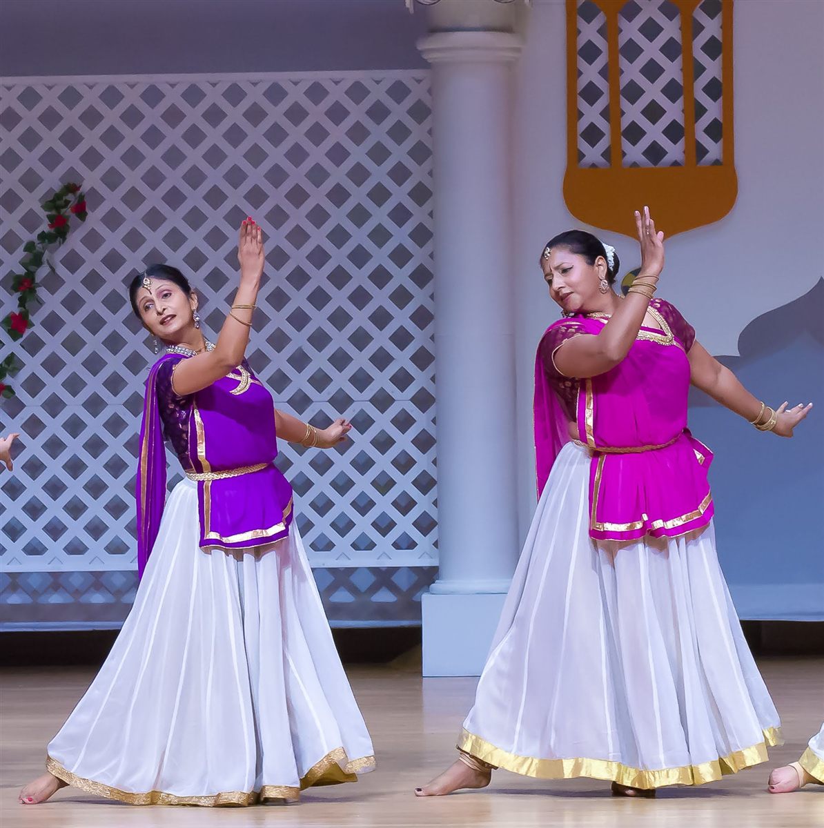 Sapna Adhikari and Aarti Gupta performing Kathak on stage in purple and white